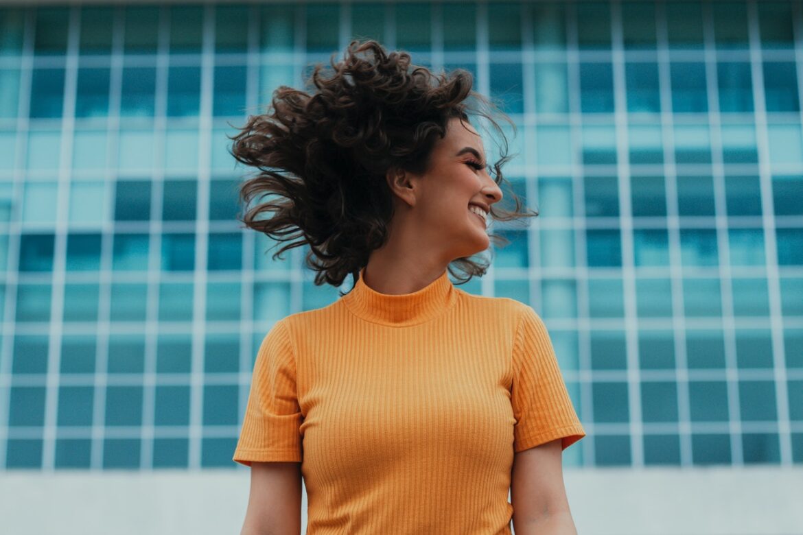 Glad kvinde har orange trøje på